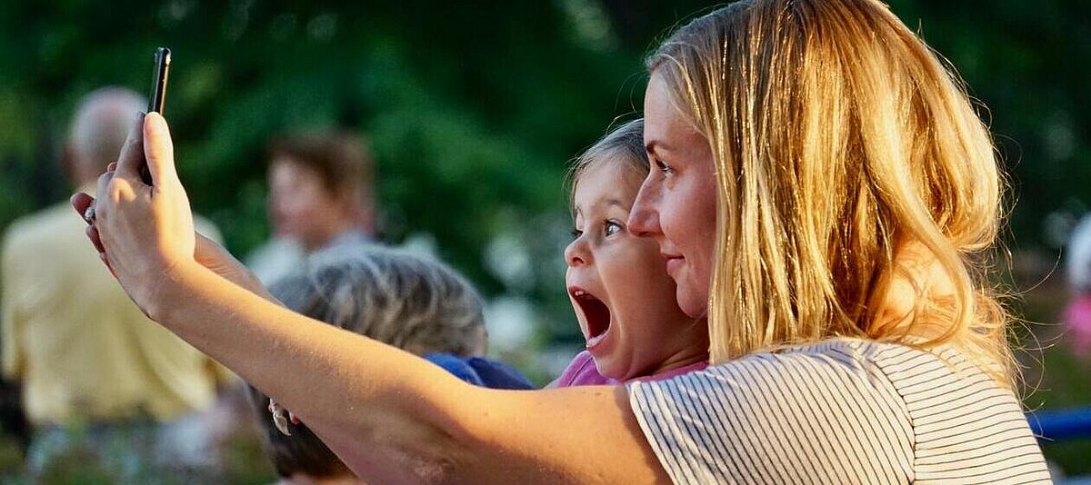 Eine Frau mit Kinder macht ein Selfie mit dem Mobiltelefon.
