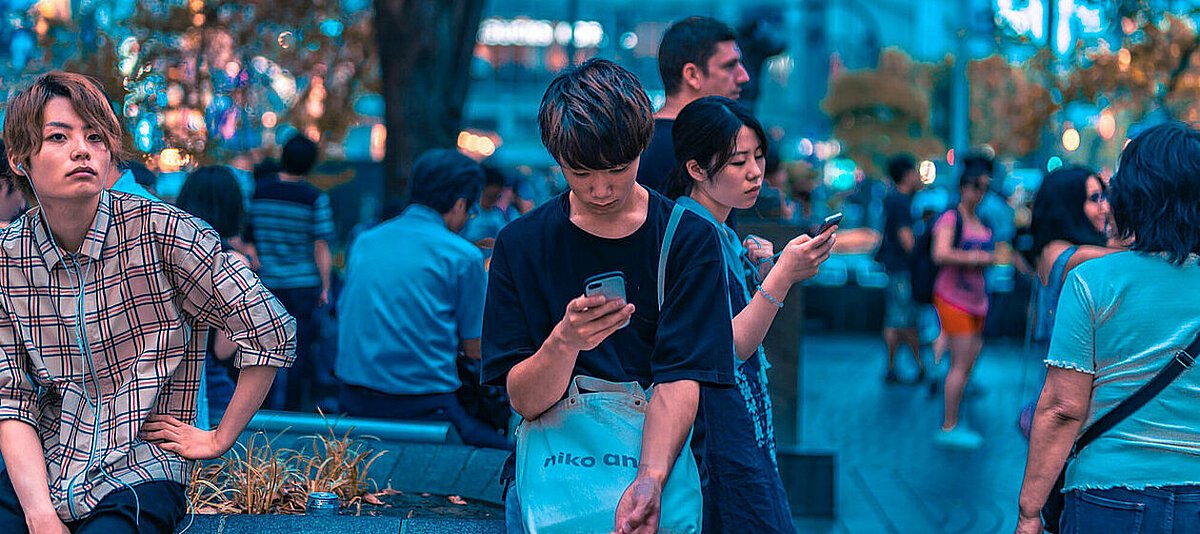 Mehrere junge Menschen schauen auf ihre Smartphones