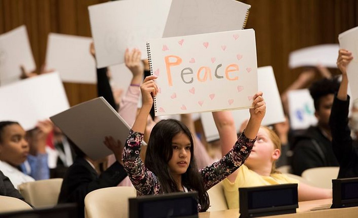 Mädchen hält ein Schild mit der Aufschrift "Peace"